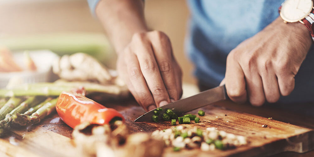 moneyplus man chopping hot tips to cut the cost of cooking