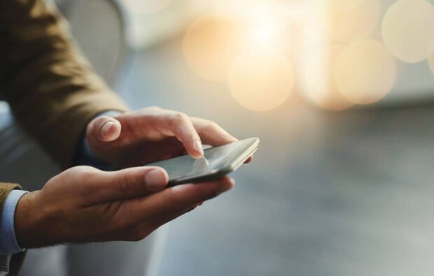 man holding phone moneyplus man holding phone save money on your phone contract