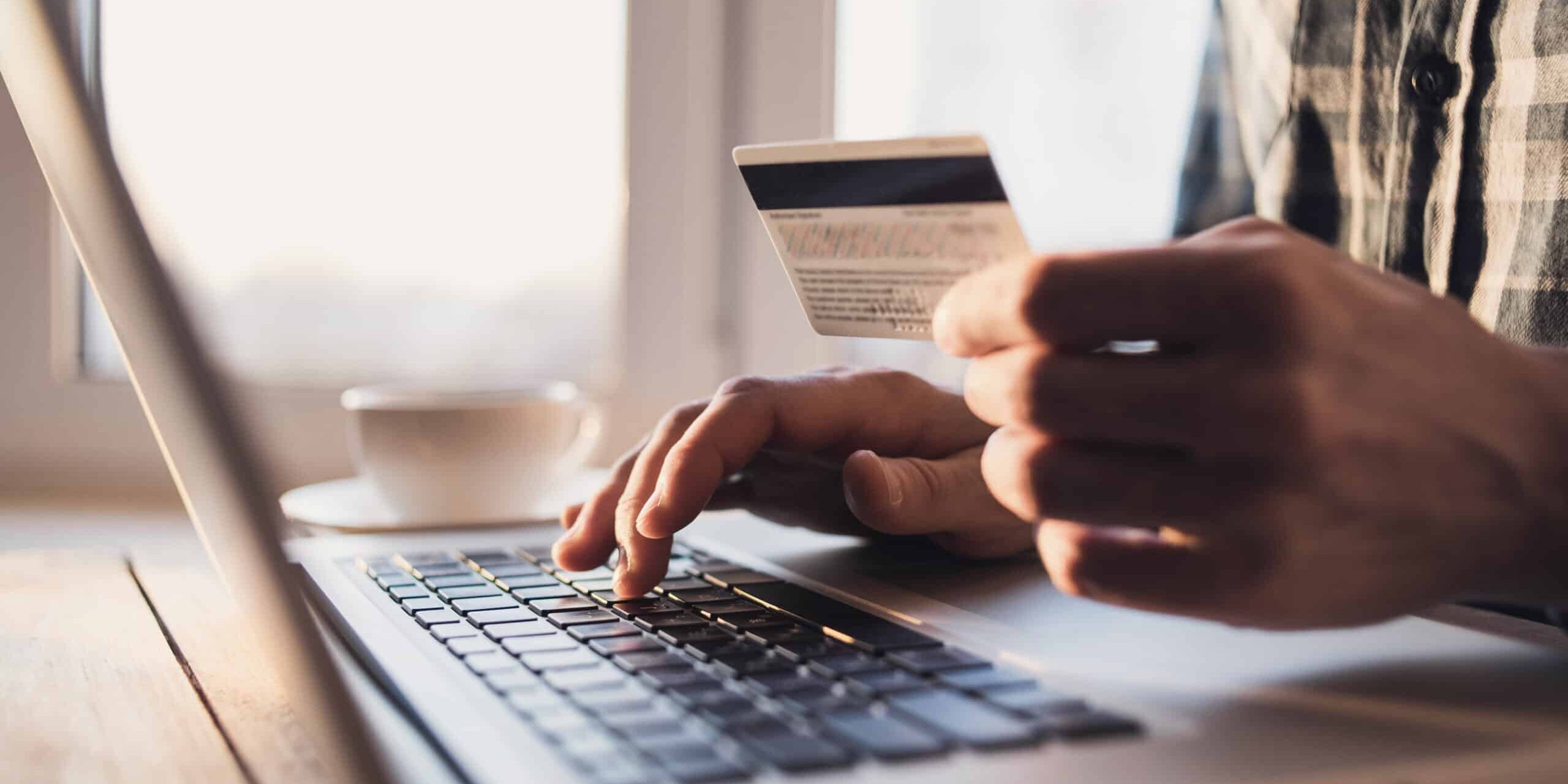 Man,Holding,Credit,Card,And,Using,Laptop.,Businessman,Or,Entrepreneur person with credit card