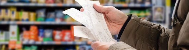 cost-of-living-banner Man reading shopping receipt