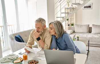 man and woman sitting at table looking at paperwork