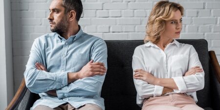 Who is responsible for debt after a separation (feature) Man and woman separated on a sofa