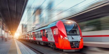 Return-Train-Tickets-feature Image of a red train driving fast on the tracks