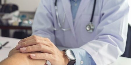 Image of a doctor holding a patients hand.