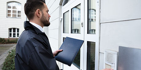 Man Standing At The Entrance Of The House Pressing The Door Bell