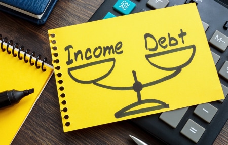 What does debt to income ratio mean_ feature Image of a scale with income on one side and debt on the other.