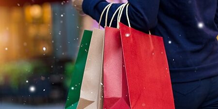 Christmas shopping – shopping bags in hand with snowflake on chr