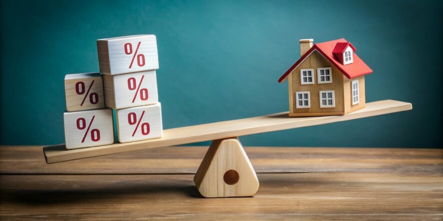 A wooden seesaw balances a house against blocks with percentage A wooden seesaw balancing house blocks and percentage blocks.