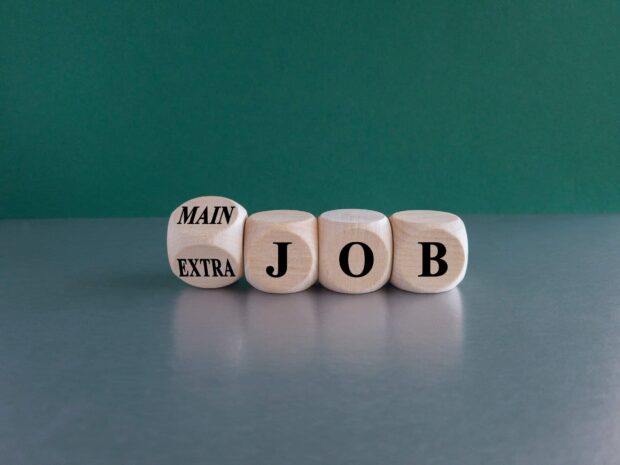 Wooden blocks displaying "MAIN JOB" or "EXTRA JOB", symbolising career choices.