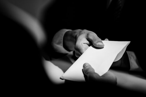 People exchanging blank envelope