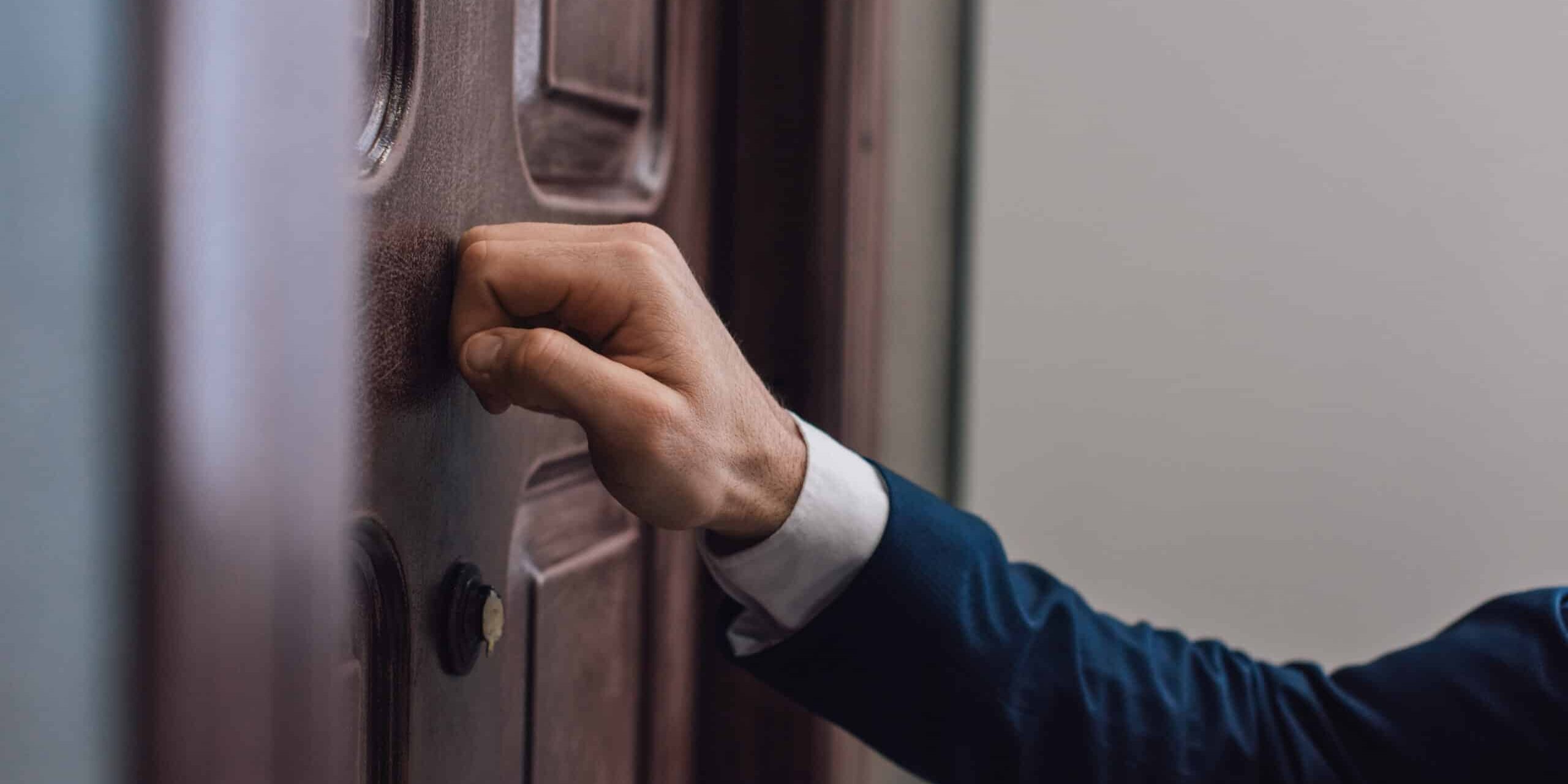Cropped view of collector knocking on door with hand
