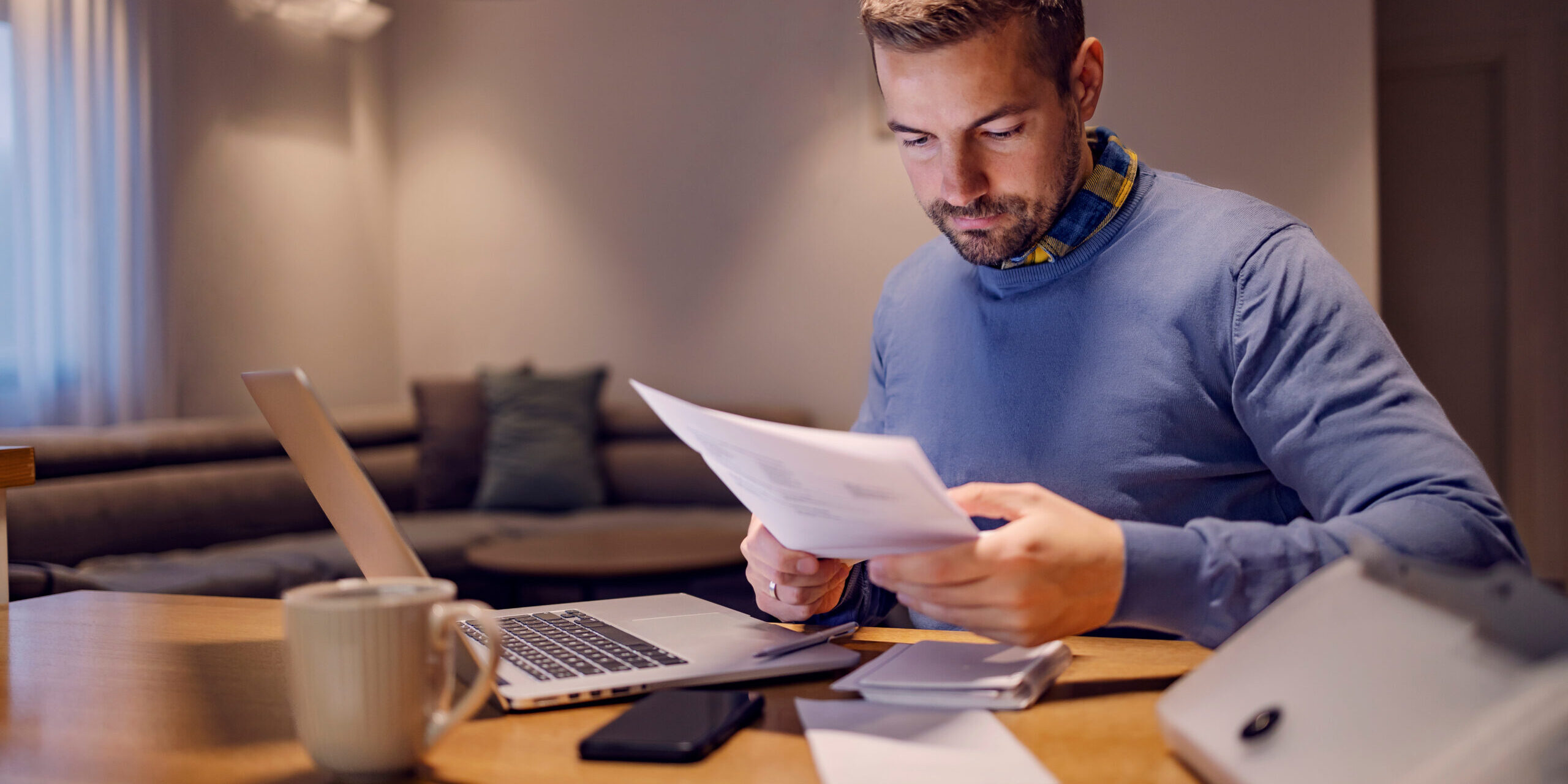 A casual businessman doing paperwork and working from home.
