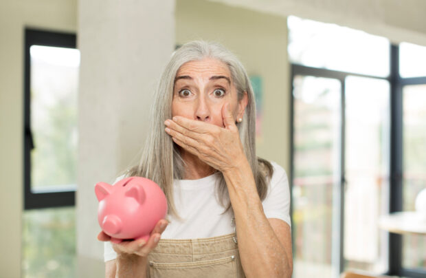 Shocked lady holding a piggybank