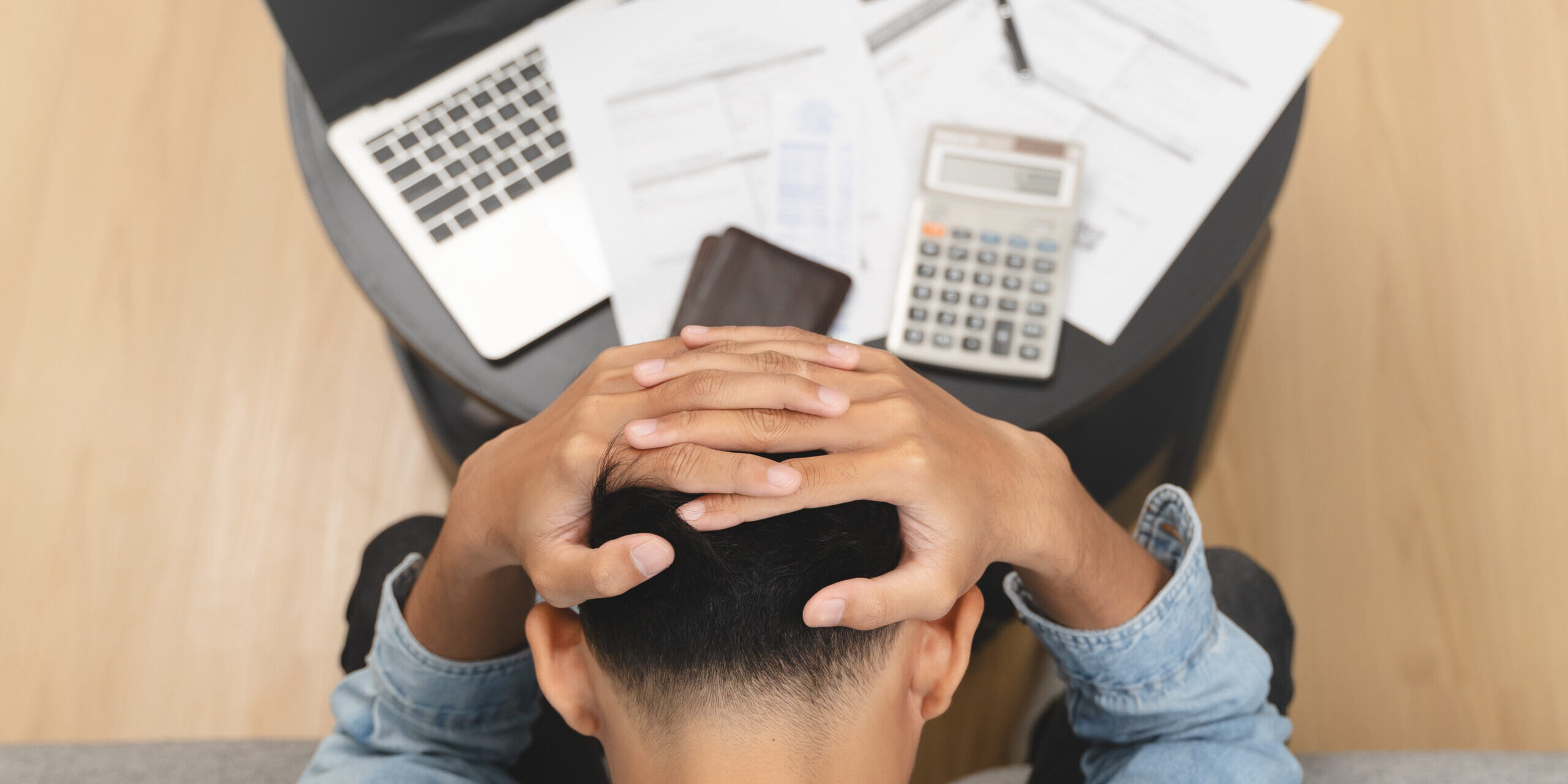 Man holding his head worrying about bills
